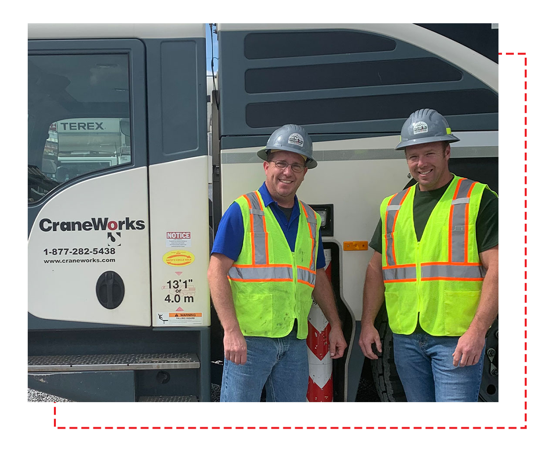 men in safety vests posing in front of work truck